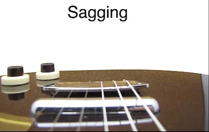 chrome guitar bridge on steel surface with dramatic lighting and sharp industrial details